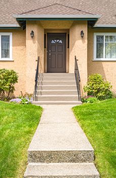 Main entrance of old family house with concrete pathway over front yard lawn