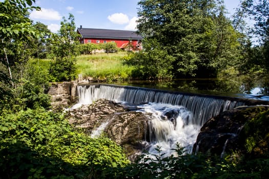 A small waterfall off an old powerplant dam, in the forest