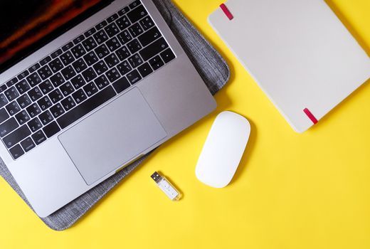 Working equipment with Laptop computers, notebook and wireless mouse on yellow background.