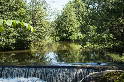 A small waterfall off an old powerplant dam, in the forest