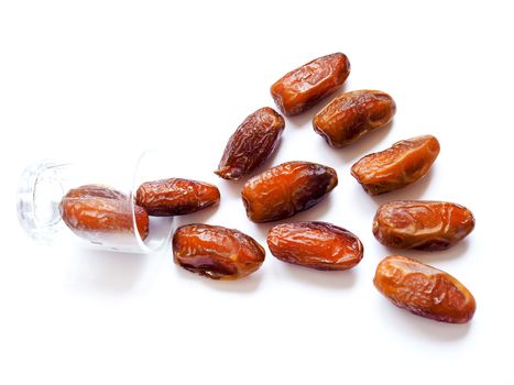 Dried dates fruit and clear glass isolated on white background