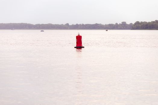 A red buoy on the Dnieper river in Kiev, Ukraine, for the safety and security of the boats travelling on the water. Selective focus