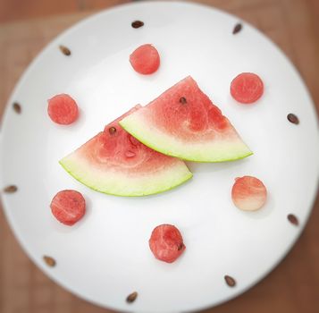 Chill pink color slices of watermelon with round shape cut pieces in white plate and good drink for summer days and healthy fruit and also to keep body hydrate drink