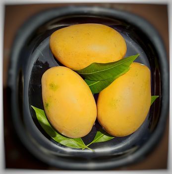 Fresh mangoes beautifully kept in black plate and tasty summer fruit and also used for occasional