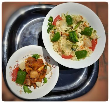 Colorful Delicious Veg fried rice with spicy indian mushroom gravy in white bowl and it's one of favorite restaurant cuisine food