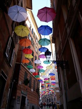 Genova, Italy - 06/01/2020: Bright abstract background of jumble of rainbow colored umbrellas over the city celebrating gay pride