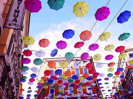 Genova, Italy - 06/01/2020: Bright abstract background of jumble of rainbow colored umbrellas over the city celebrating gay pride