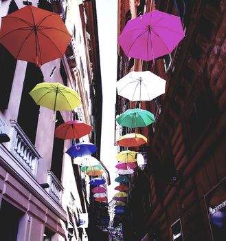 Genova, Italy - 06/01/2020: Bright abstract background of jumble of rainbow colored umbrellas over the city celebrating gay pride