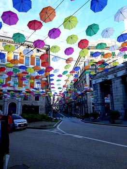 Genova, Italy - 06/01/2020: Bright abstract background of jumble of rainbow colored umbrellas over the city celebrating gay pride