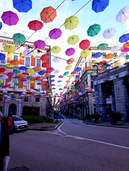 Genova, Italy - 06/01/2020: Bright abstract background of jumble of rainbow colored umbrellas over the city celebrating gay pride