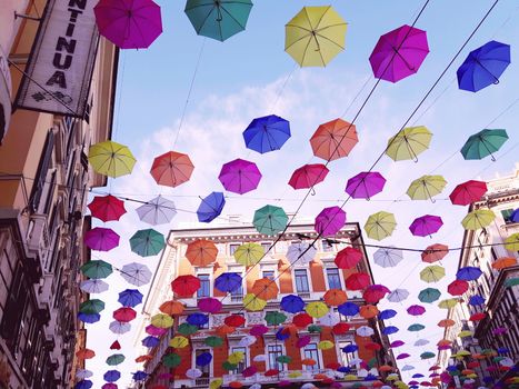 Genova, Italy - 06/01/2020: Bright abstract background of jumble of rainbow colored umbrellas over the city celebrating gay pride