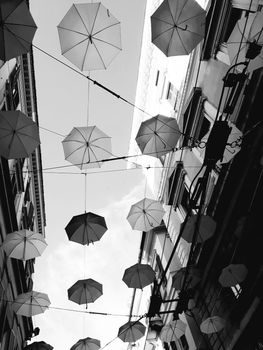 Genova, Italy - 06/01/2020: Bright abstract background of jumble of rainbow colored umbrellas over the city celebrating gay pride