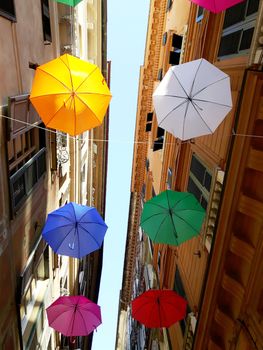 Genova, Italy - 06/01/2020: Bright abstract background of jumble of rainbow colored umbrellas over the city celebrating gay pride