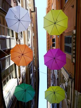 Genova, Italy - 06/01/2020: Bright abstract background of jumble of rainbow colored umbrellas over the city celebrating gay pride