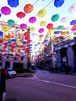 Genova, Italy - 06/01/2020: Bright abstract background of jumble of rainbow colored umbrellas over the city celebrating gay pride