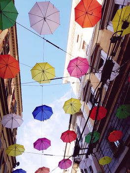 Genova, Italy - 06/01/2020: Bright abstract background of jumble of rainbow colored umbrellas over the city celebrating gay pride