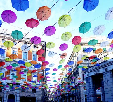 Genova, Italy - 06/01/2020: Bright abstract background of jumble of rainbow colored umbrellas over the city celebrating gay pride