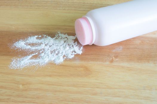 pink talcum baby powder container on wooden background