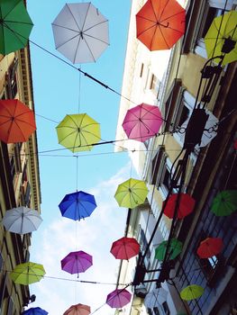 Genova, Italy - 06/01/2020: Bright abstract background of jumble of rainbow colored umbrellas over the city celebrating gay pride