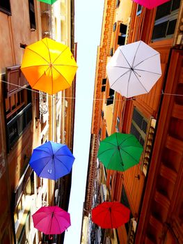 Genova, Italy - 06/01/2020: Bright abstract background of jumble of rainbow colored umbrellas over the city celebrating gay pride