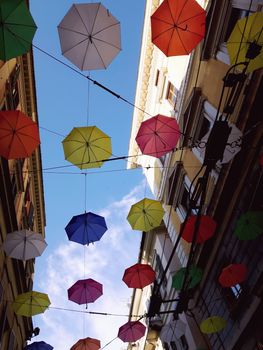 Genova, Italy - 06/01/2020: Bright abstract background of jumble of rainbow colored umbrellas over the city celebrating gay pride