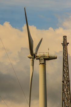 Close up of wind turbine in a wind farm against a clear blue sky producing alternative energy