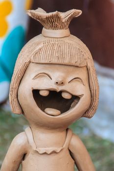 Happy Ceramic dolls for garden decoration. Cute ceramic clay pottery of girl show her up-swept bun and broken tooth that happy laughing until her eyes closed. Happy dolls for garden decoration.