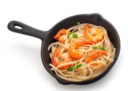 Fried shrimps with prepared pasta in the iron pan