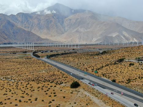 Aerial view of huge array of gigantic wind turbines spreading over the desert in Palm Springs wind farm. California. USA. Aerial view of wind turbines generating electricity. 