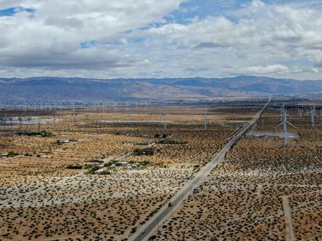 Aerial view of huge array of gigantic wind turbines spreading over the desert in Palm Springs wind farm. California. USA. Aerial view of wind turbines generating electricity. 
