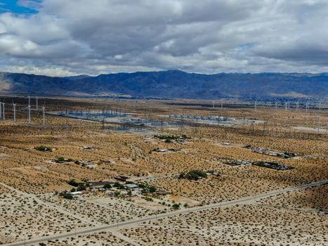 Aerial view of huge array of gigantic wind turbines spreading over the desert in Palm Springs wind farm. California. USA. Aerial view of wind turbines generating electricity. 