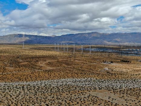 Aerial view of huge array of gigantic wind turbines spreading over the desert in Palm Springs wind farm. California. USA. Aerial view of wind turbines generating electricity. 