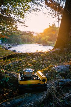 Picnic gas stove and aluminum teapot for boiling water during camping