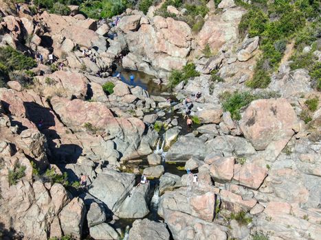 Aerial view of Los Penasquitos Canyon Preserve with the creek waterfall and people enjoying the water. Urban park with trails and river in San Diego, California. USA