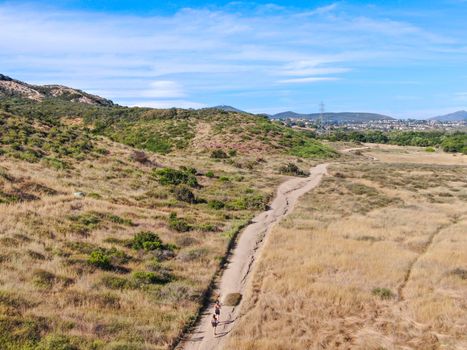 Aerial view of Los Penasquitos Canyon Preserve with tourists, hikers and bikers on the trails,. Urban park with mountain, forest and trails in San Diego, California. USA