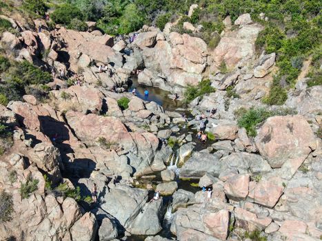 Aerial view of Los Penasquitos Canyon Preserve with the creek waterfall and people enjoying the water. Urban park with trails and river in San Diego, California. USA