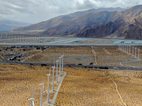 Aerial view of huge array of gigantic wind turbines spreading over the desert in Palm Springs wind farm. California. USA. Aerial view of wind turbines generating electricity. 