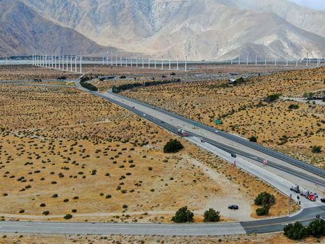 Aerial view of huge array of gigantic wind turbines spreading over the desert in Palm Springs wind farm. California. USA. Aerial view of wind turbines generating electricity. 