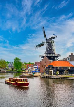 A windmill along the canals in Haarlem, Netherlands on a clear day.