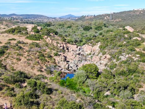 Aerial view of Los Penasquitos Canyon Preserve with the creek waterfall and people enjoying the water. Urban park with trails and river in San Diego, California. USA