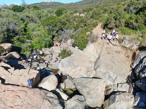 Aerial view of Los Penasquitos Canyon Preserve with the creek waterfall and people enjoying the water. Urban park with trails and river in San Diego, California. USA