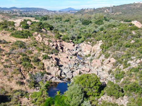 Aerial view of Los Penasquitos Canyon Preserve with the creek waterfall and people enjoying the water. Urban park with trails and river in San Diego, California. USA