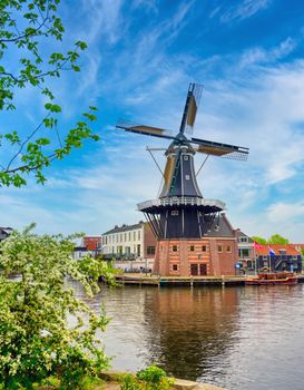 A windmill along the canals in Haarlem, Netherlands on a clear day.