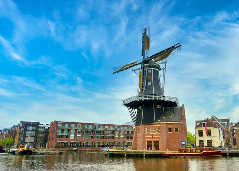 A windmill along the canals in Haarlem, Netherlands on a clear day.