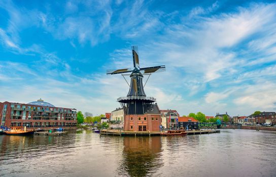 A windmill along the canals in Haarlem, Netherlands on a clear day.