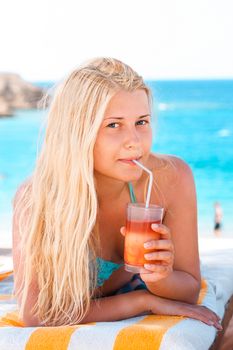 Woman with blond hair enjoying cocktail drink and beach lifestyle in summertime, holiday travel and leisure concept