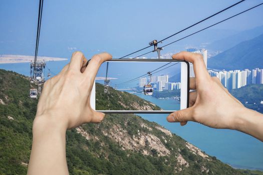 Girl taking pictures on mobile smart phone in Cable car,from Hong Kong Ocean Park