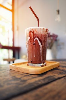 Iced chocolate shake on wood and sunlight background