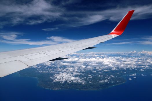 Aerial view from the plane over Punta Cana, Dominican Republic. Flying above the clouds. Wing of an airplane flying above the Atlantic Ocean.