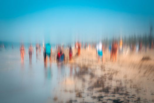 Abstract photo effect of people walking on the beach in the colorful impressionist style. Soft focus. A blurring technique creates a unique impressionist style. Pastel colours. Bavaro beach, Punta Cana, Dominican Republic.
